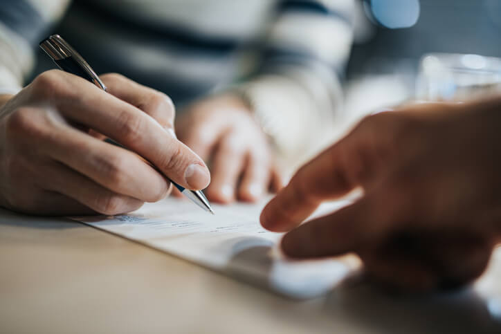 Personal injury attorney and client signing papers